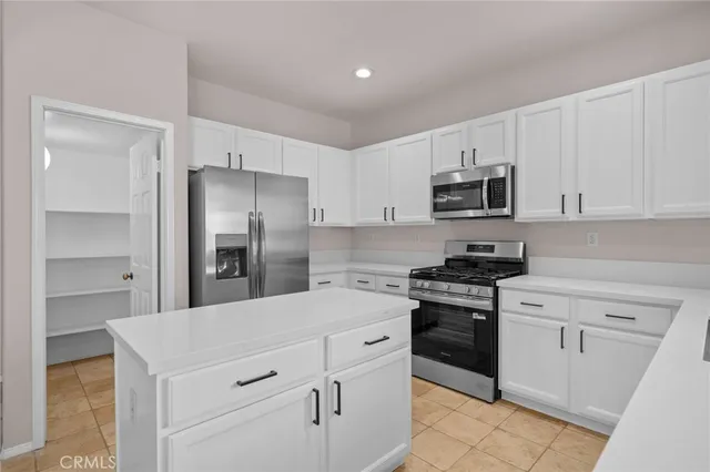 a kitchen with granite countertop a stove a sink and a microwave