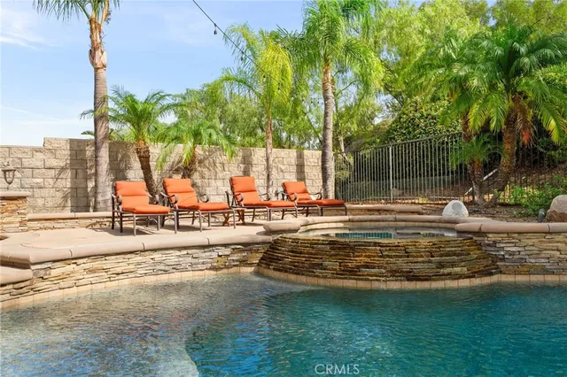 a view of a house with pool and sitting area