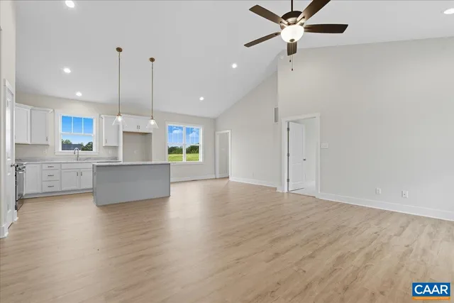 a view of kitchen with stainless steel appliances refrigerator wooden floor and a ceiling fan