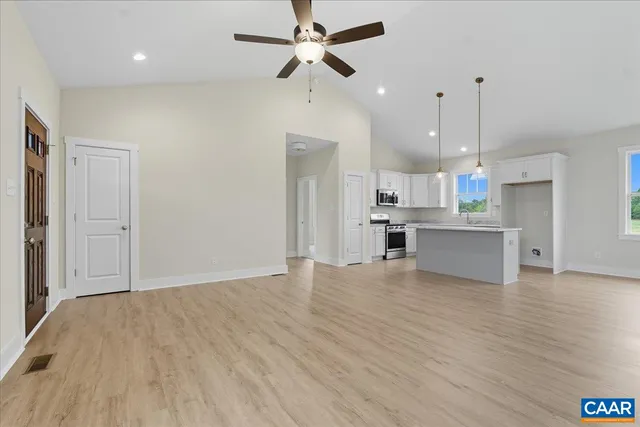 a view of a kitchen with wooden floor and a ceiling fan