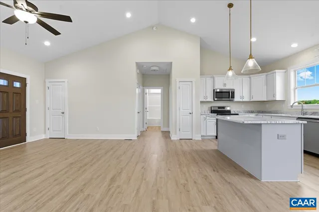 a view of kitchen with stainless steel appliances granite countertop cabinets and wooden floor