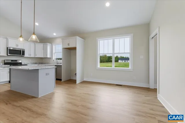 a kitchen with stainless steel appliances granite countertop a stove a sink a refrigerator and a microwave