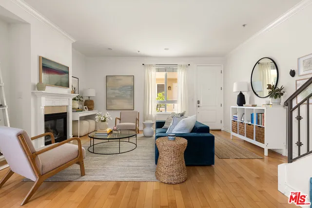 a living room with furniture a fireplace and a large window