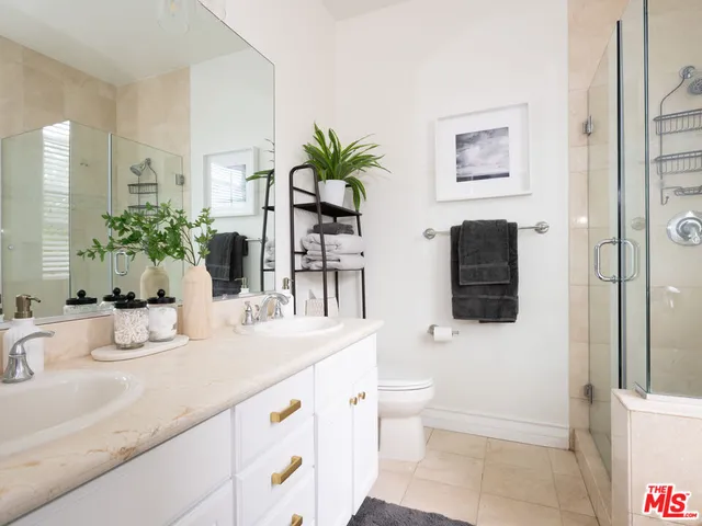 a bathroom with a granite countertop sink a toilet and shower