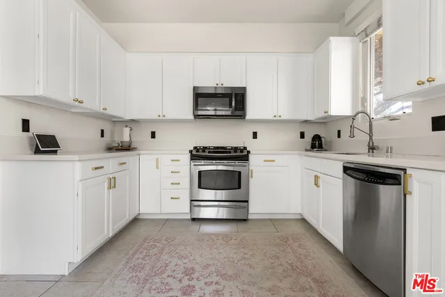a kitchen with white cabinets and white appliances