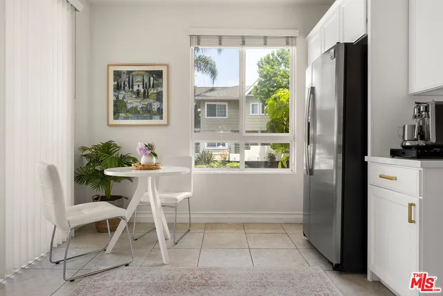 a kitchen with a refrigerator and a dining table