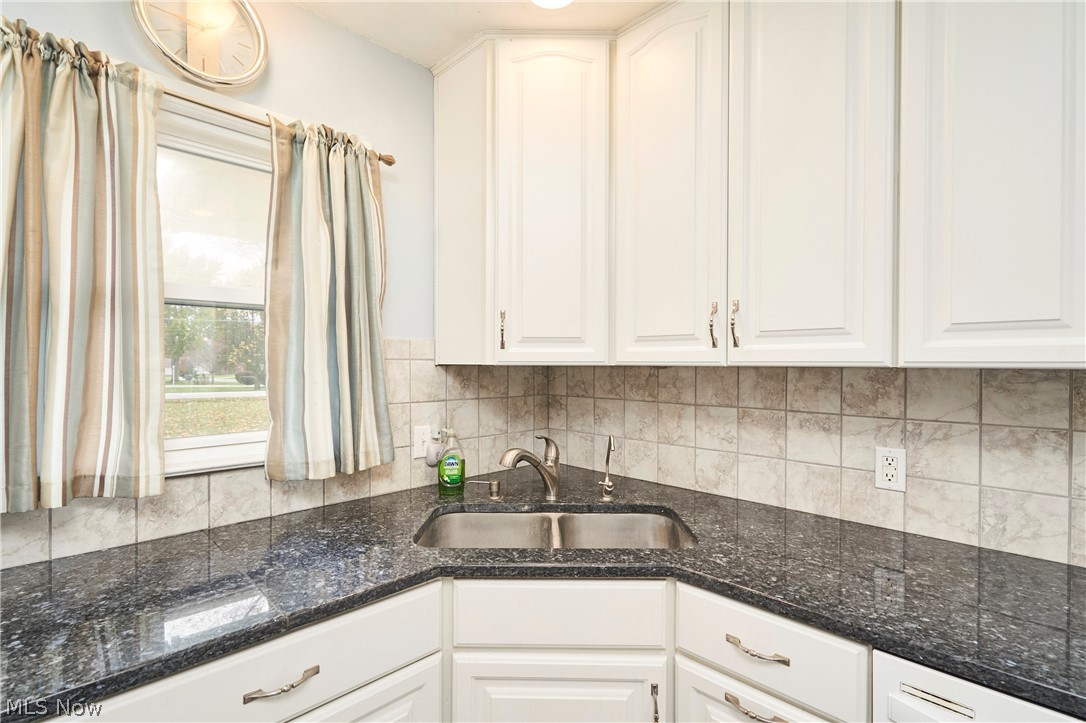 2941 Sweitzer Road Uniontown, OH 44685 - Photo 4 of 16 Kitchen featuring white cabinetry, dark stone counters, and decorative backsplash