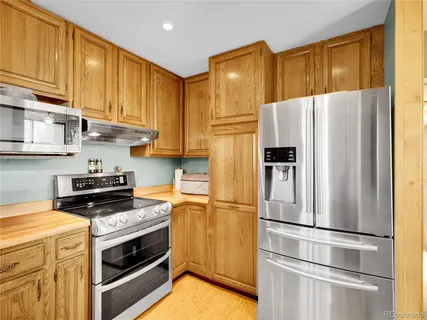 a kitchen with stainless steel appliances a refrigerator stove and cabinets