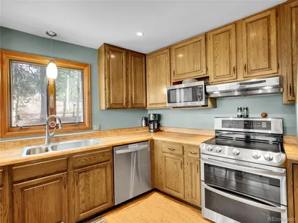 a kitchen with stainless steel appliances granite countertop a sink a stove and cabinets