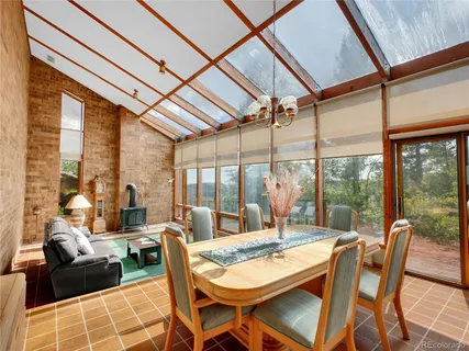 a dining room with furniture a chandelier and glass windows