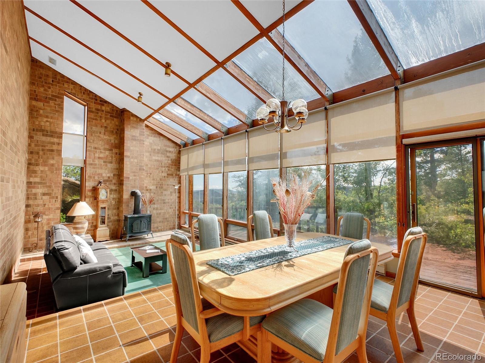 29752 Bearcat Trail Conifer, CO 80433 - Photo 15 of 50 a dining room with furniture a chandelier and glass windows
