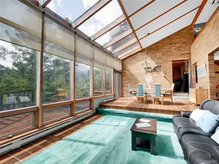 a living room with patio furniture and a floor to ceiling window
