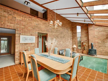 a dining room with furniture and a floor to ceiling window