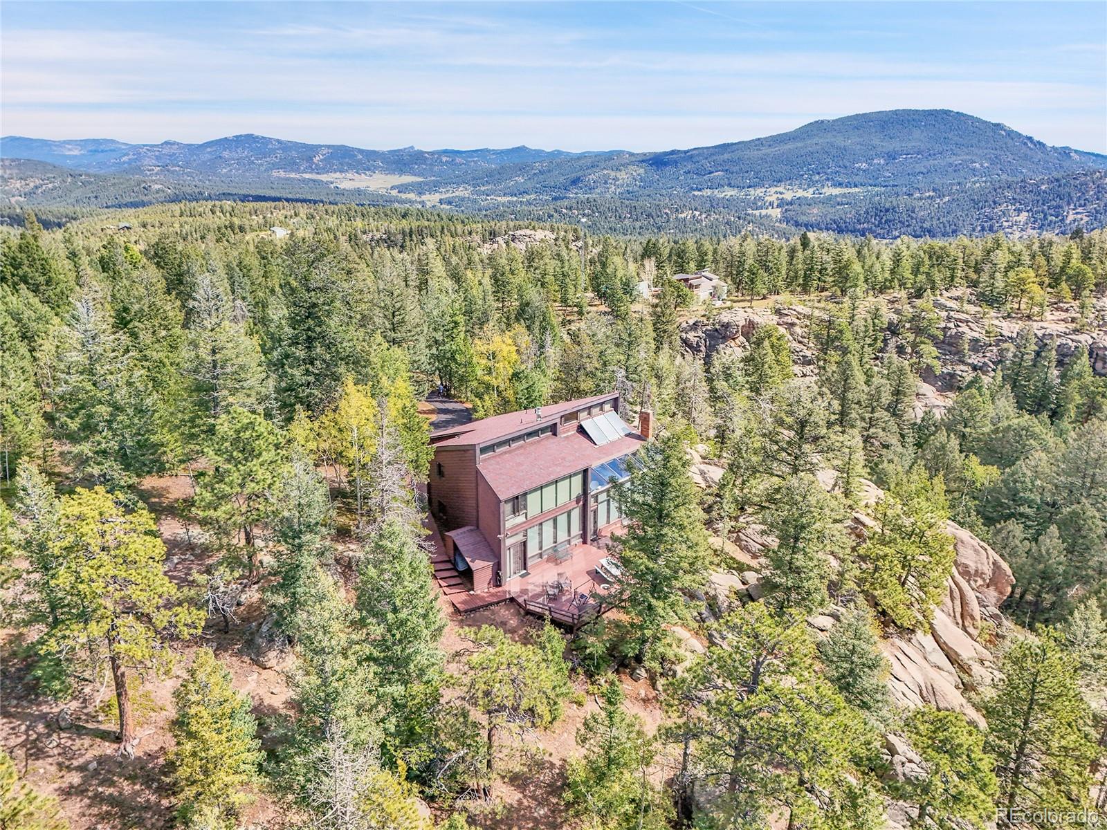 29752 Bearcat Trail Conifer, CO 80433 - Photo 2 of 50 a view of a lush green field with a tree in a yard