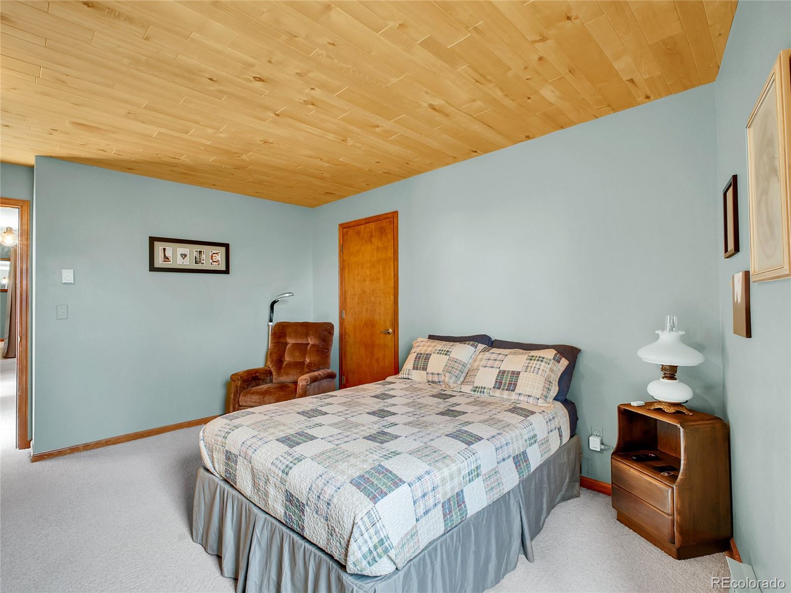 29752 Bearcat Trail Conifer, CO 80433 - Photo 21 of 50 a bedroom with a bed and a lamp