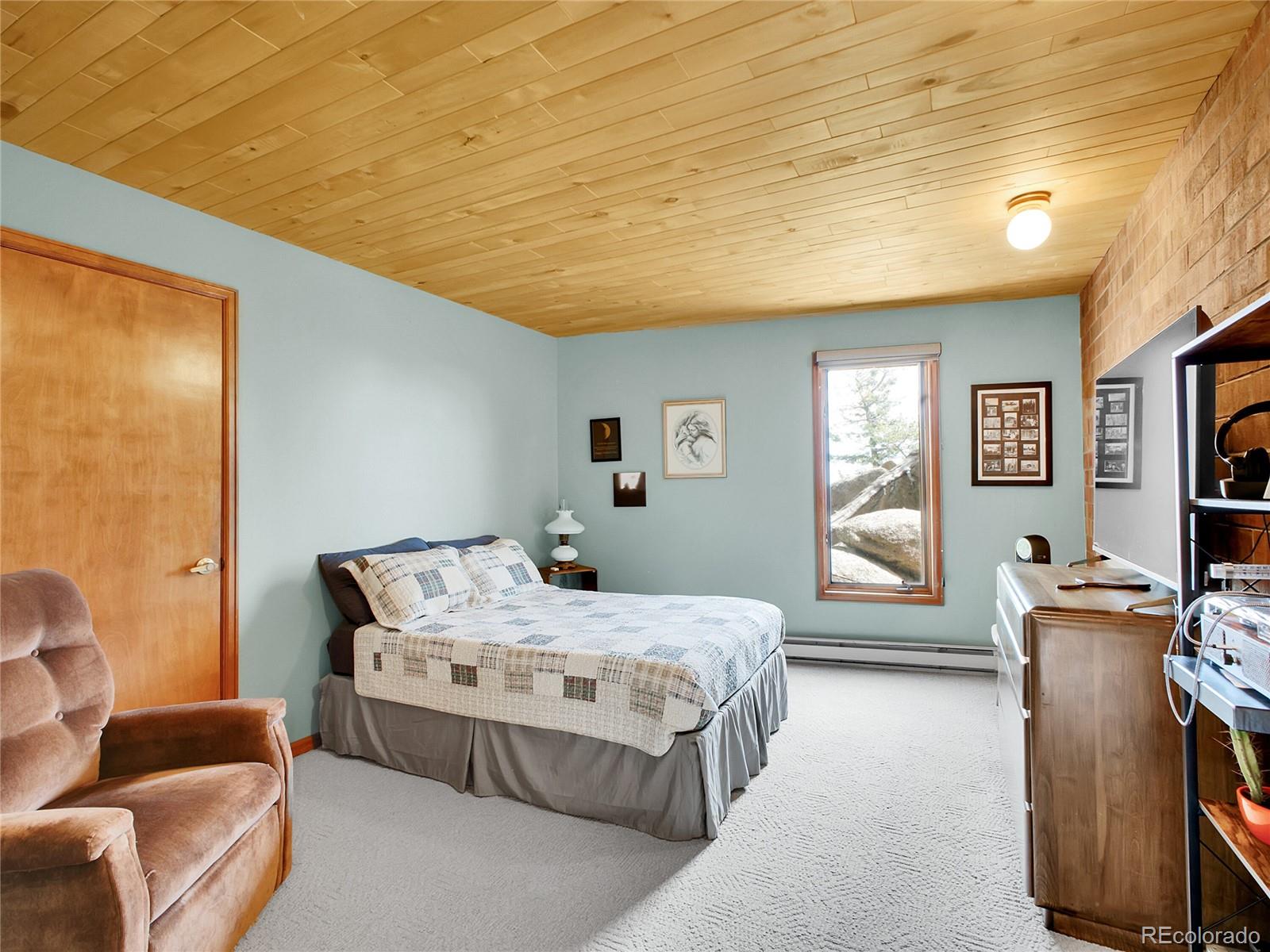 29752 Bearcat Trail Conifer, CO 80433 - Photo 22 of 50 a bedroom with a bed and furniture