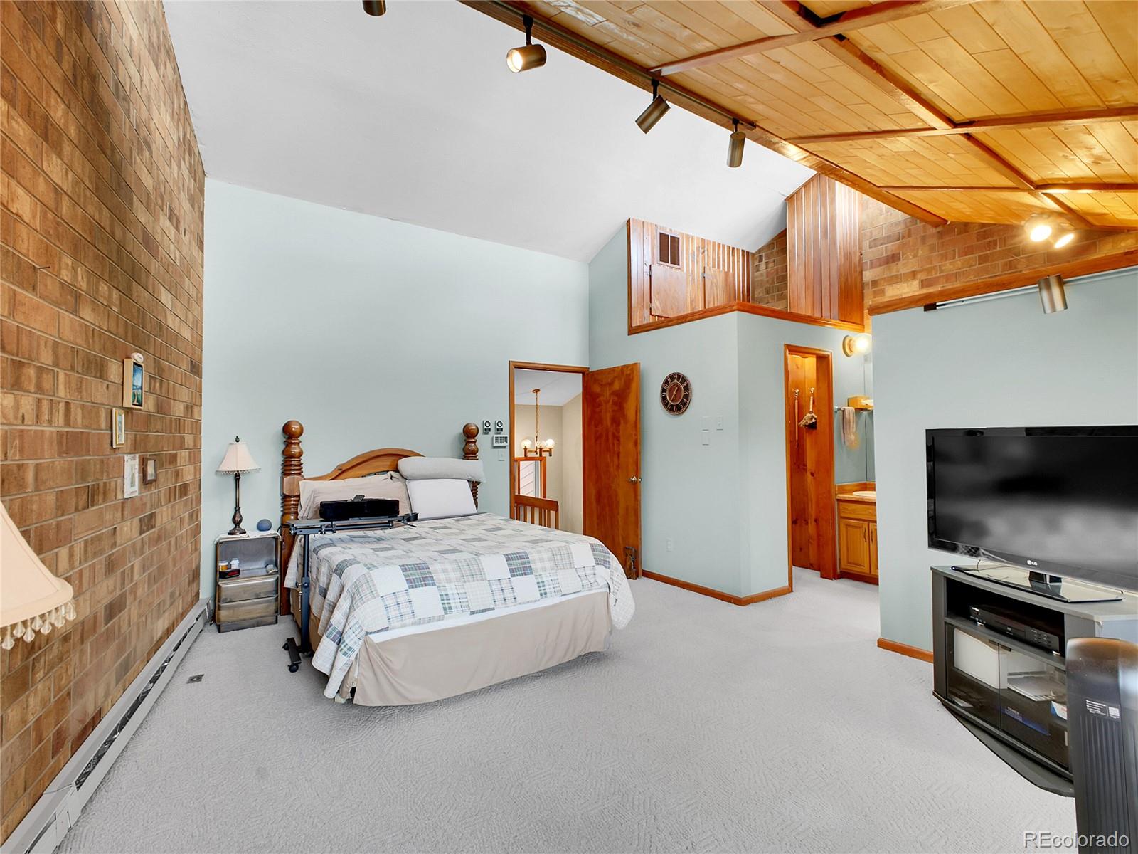 29752 Bearcat Trail Conifer, CO 80433 - Photo 26 of 50 a bedroom with a bed and a television