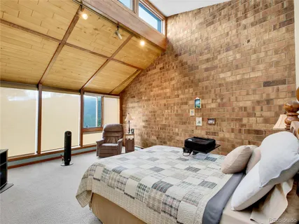 a bedroom with a bed a couch and a window