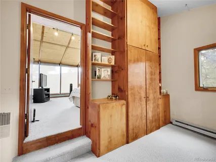 a view of a hallway with a livingroom and a window
