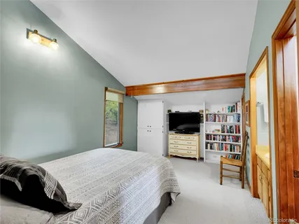 a bedroom with a bed and a flat tv screen on the dresser