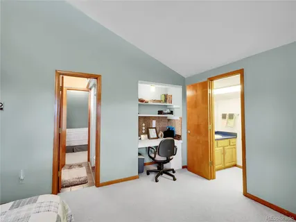 a view of a workspace with furniture and a window