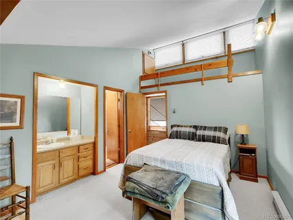 a bedroom with a bed and large windows