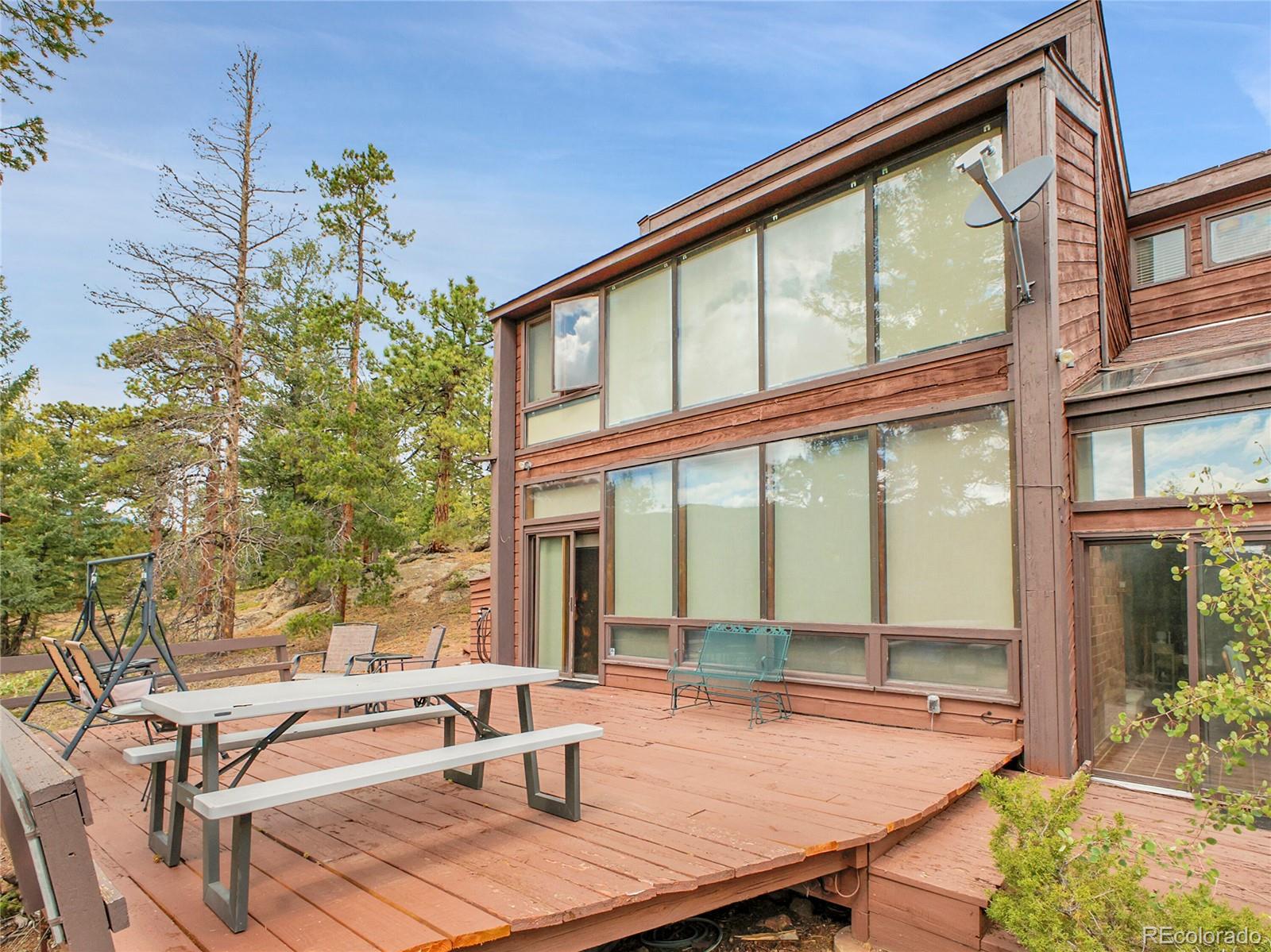29752 Bearcat Trail Conifer, CO 80433 - Photo 43 of 50 a dining room with glass windows and glass table