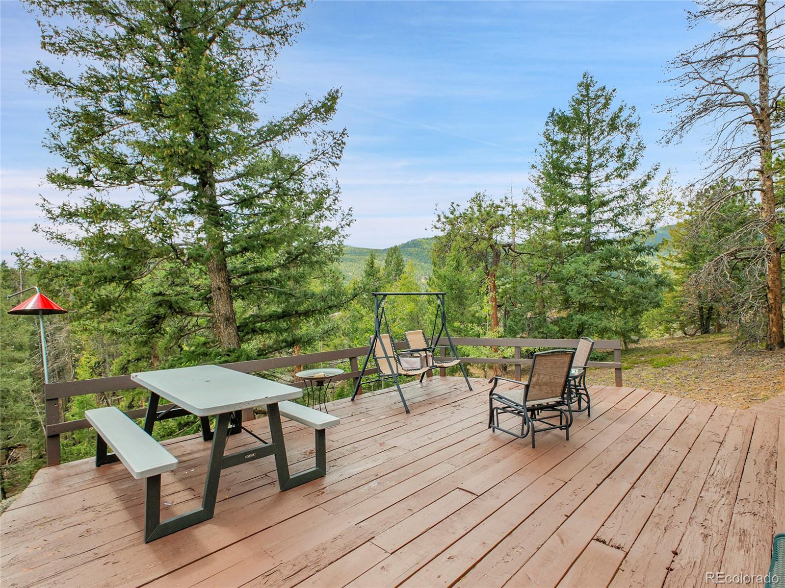 29752 Bearcat Trail Conifer, CO 80433 - Photo 44 of 50 a view of a chairs and table on the wooden floor