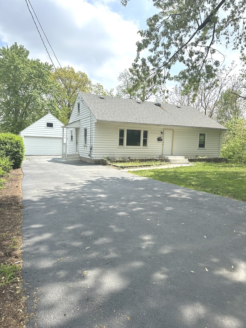 a front view of a house with a yard and trees
