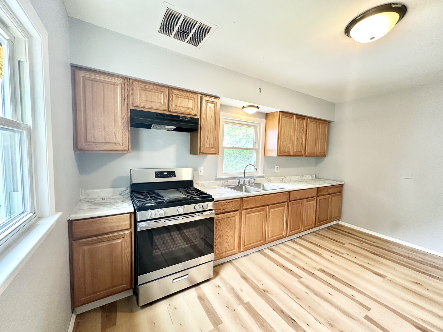 301 Illinois Avenue Elgin, IL 60120 - Photo 2 of 14 a kitchen with stainless steel appliances granite countertop a stove and a sink