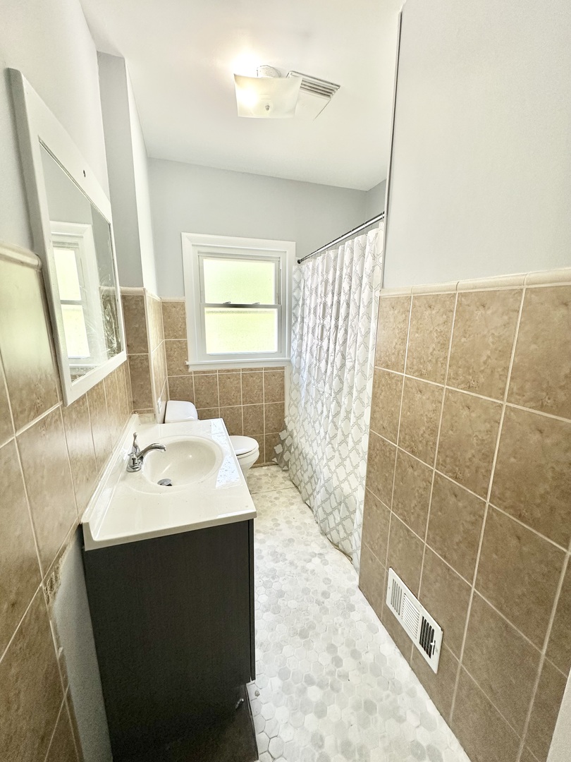 301 Illinois Avenue Elgin, IL 60120 - Photo 6 of 14 a bathroom with a sink and a mirror