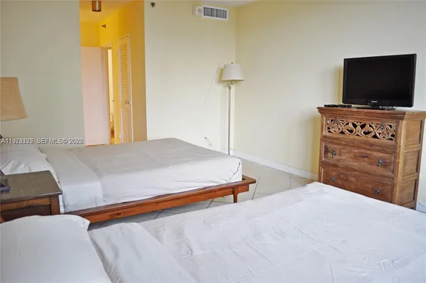 a bedroom with a bed and flat screen tv