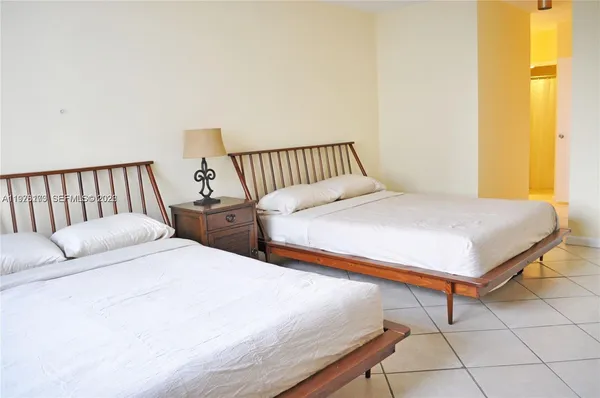 a bedroom with 2 bed and a window