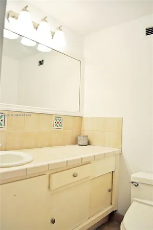 a bathroom with a sink a toilet and mirror