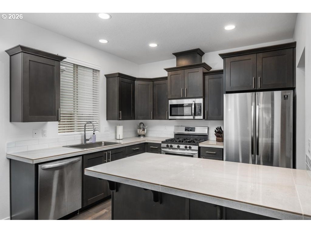 859 South 23rd Avenue Cornelius, OR 97113 - Photo 8 of 39 a kitchen with stainless steel appliances a sink stove refrigerator and cabinets