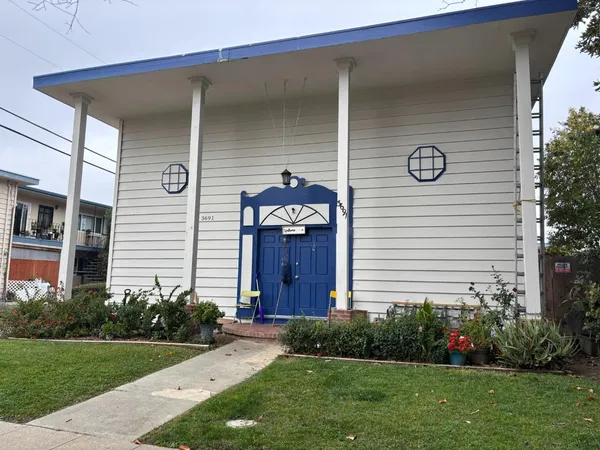 a front view of a house with a garden and plants