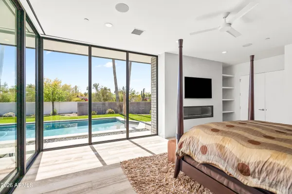 a bedroom with a bed and a flat tv screen next to a window