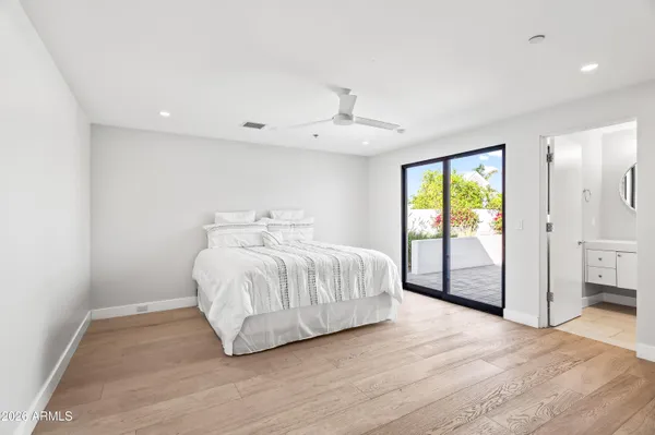 a spacious bedroom with a large bed and a chandelier