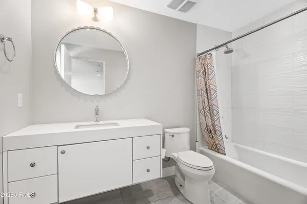 a bathroom with a toilet sink vanity tub and shower