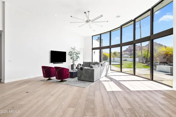 a living room with furniture a flat screen tv and a floor to ceiling window