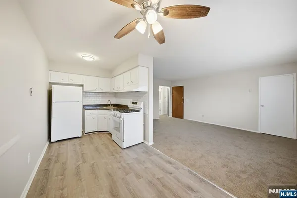 a view of a kitchen with a sink and dishwasher a refrigerator with wooden floor