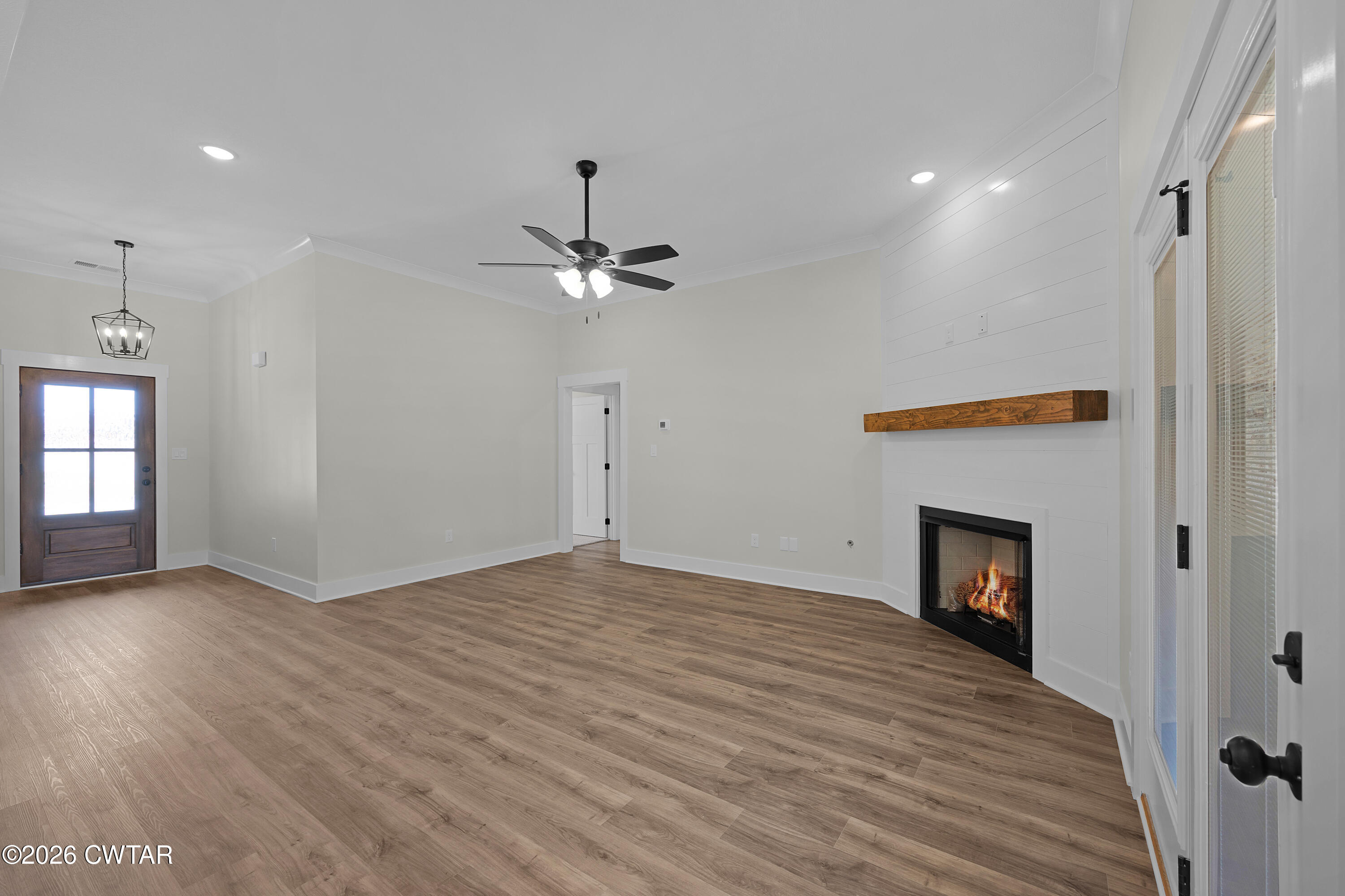 404 Fairway Boulevard Jackson, TN 38305 - Photo 4 of 16 an empty room with wooden floor and fireplace