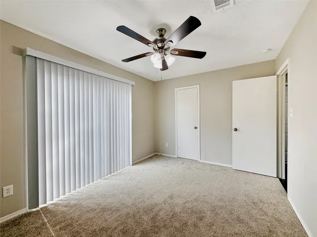 a view of an empty room with a ceiling fan