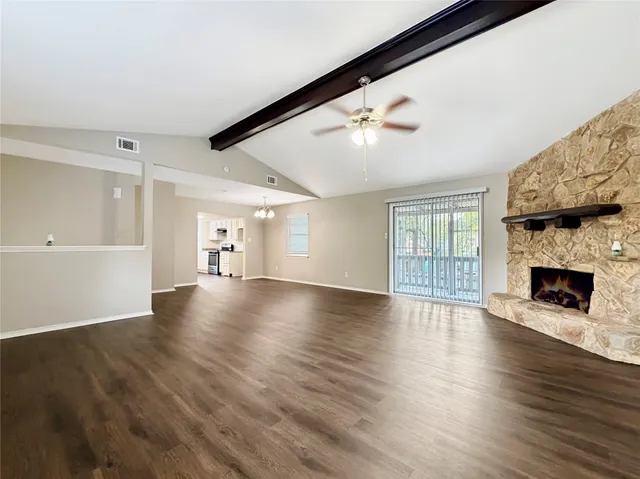 a view of a livingroom with wooden floor and a fireplace