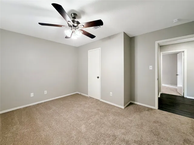 an empty room with closet and ceiling fan