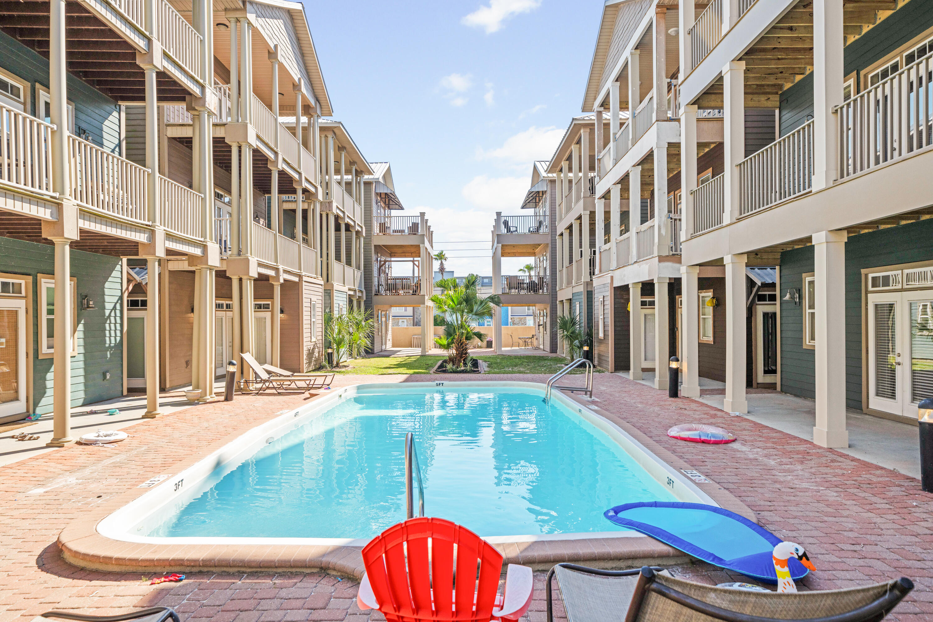 6236 Thomas Drive Panama City Beach, FL 32408 - Photo 1 of 36 a view of a swimming pool with a lounge chairs in front of building