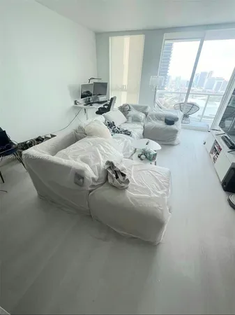 a bedroom with bed and a large window