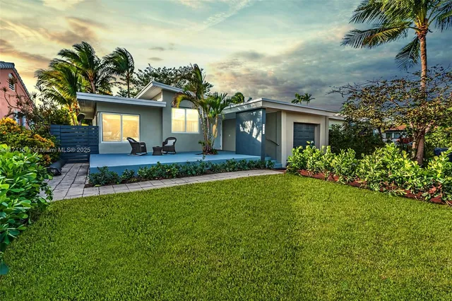 a front view of a house with a yard and potted plants