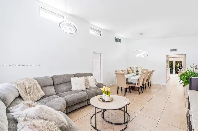 a living room with furniture a rug and a potted plant
