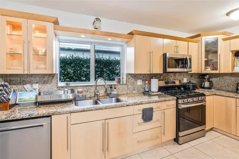 a kitchen with granite countertop a sink stainless steel appliances and a counter space